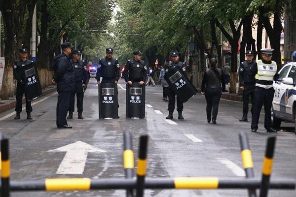 Policemen with riot gear stand guard behind a barricade near the site of an explosives attack in Xinjiang Uyghur Autonomous Region on May 23, 2014. Photo courtesy of HRW / © 2014 Reuters