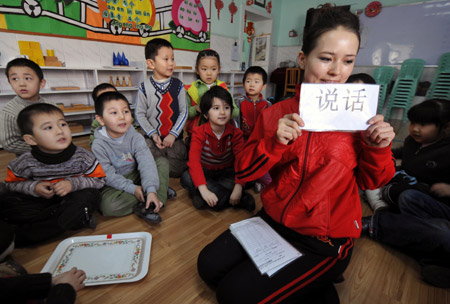 A Chinese teacher teaches Chinese characters to children at a kindergarten in Urumqi, capital of northwest China's Xinjiang Uygur Autonomous Region, Feb. 26, 2009. This kindergarten offers bilingual education to pre-primary school children of local Uygur people. (Xinhua/Zhao Ge)