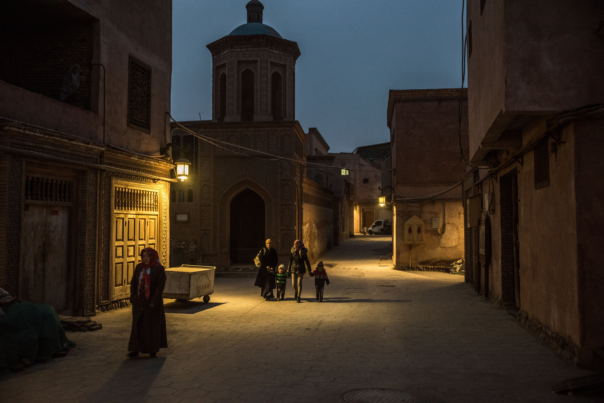 Walking past a mosque in Kashgar, a city in China’s western region of Xinjiang. More than 10 million Uighurs, a mostly Muslim minority group, live in the region. Credit Gilles Sabrie for The New York Times