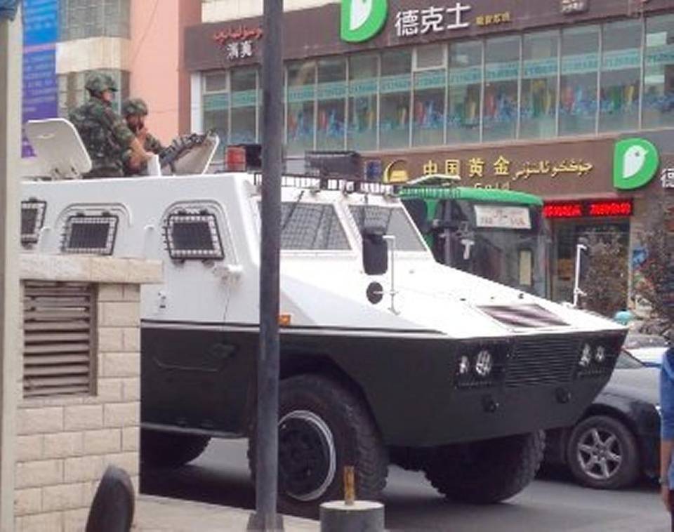 Chinese police with guns in an armored vehicle rumble through Aksu, a city in Xinjiang province, China, on July 29, 2015. Clashes between Chinese authorities and Muslim Uighurs, who resent Beijing's rule, have killed hundreds in this part of far-western China in recent years. Stuart Leavenworth McClatchy 