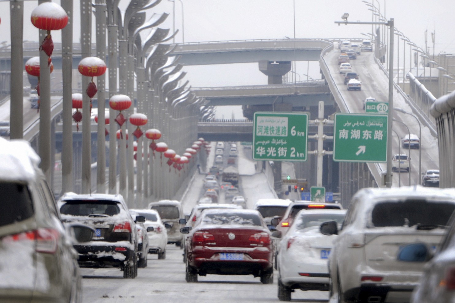 In this Monday, Feb. 20, 2017 photo released by Xinhua News Agency, vehicles run on the snow-covered road in Urumqi, capital of northwest China’s Xinjiang Uygur Autonomous Region. A prefecture in China’s Xinjiang region is requiring all vehicles to install satellite tracking systems as part of stepped-up measures against violent attacks. Traffic police in Bayingolin Mongol Autonomous Prefecture announced the regulation on Sunday, shortly after thousands of heavily armed police paraded in Urumqi and Communis