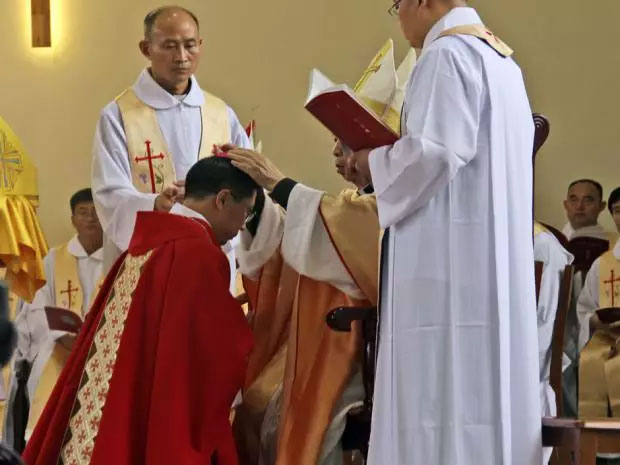 Rev. Joseph Zhang Yinlin, kneeling, takes part in an ordination ceremony to be named coadjutor bishop in Anyang city in central China's Henan province