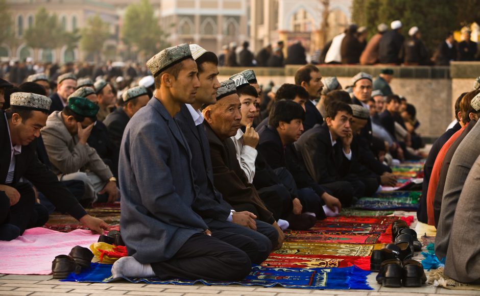 Muslim Uighurs kneel on prayer carpets outside of Id Kah Mosque at the end of Ramadan month in Kashgar, Xinjiang province western China. Source: Pete Niesen/Shutterstock