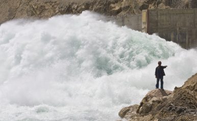 A worker directs a truck (unseen) as water gushes out from the Sangtuda-1 hydroelectric power plant in Tajikistan (May 28, 2008). Image Credit: REUTERS/Shamil Zhumatov