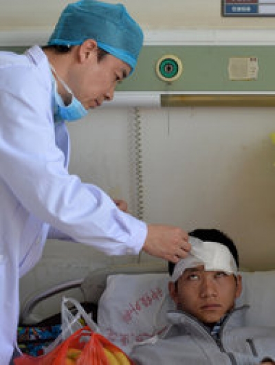 Agence France-Presse — Getty Images A doctor checking a patient who was wounded in the stabbing attack at the Kunming train station in China on Saturday.