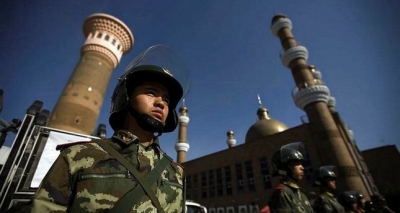 Chinese security forces patrol the entrance to a historic mosque in Xinjiang.