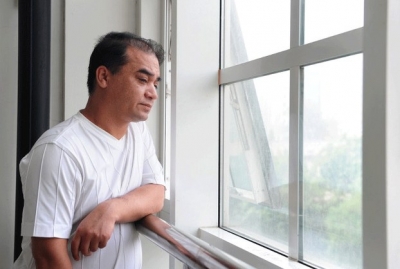 Ilham Tohti looking out of the window at Minzu University of China, where he teaches economics