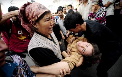 Uighurs carry a woman who fainted during a protest in Urumqi, Xinjiang province in July 2009. Police used tear gas against Han Chinese who vowed revenge for violence that killed at least 156 earlier in the week. 