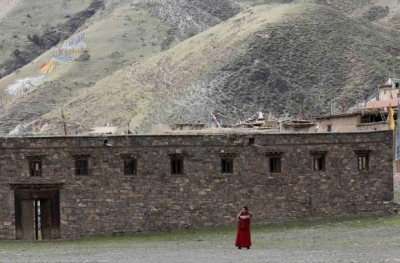   A Tibetan monk uses a mobile phone near the Dzamthang Jonang monastery in Barma township May 16, 2013.  Credit: Reuters/Kim Kyung-Hoon